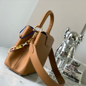 The Capucines medium-sized handbag M21652 has a deep apricot yellow gold buckle