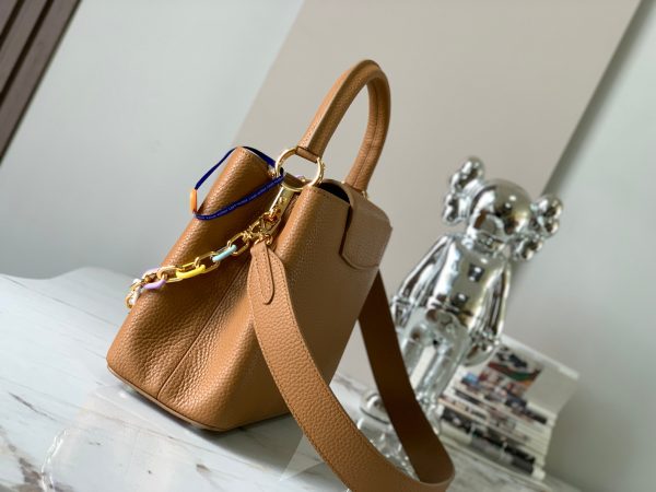 The Capucines medium-sized handbag M21652 has a deep apricot yellow gold buckle