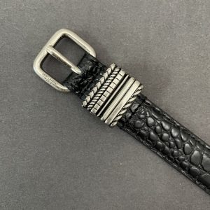The square buckle of the YSL belt is engraved with the SAINT LAURENT PARIS logo.